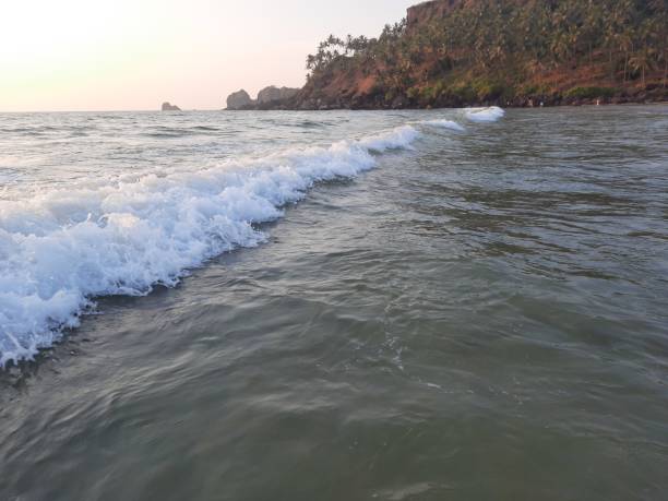 waves breaking on the beach, goa beach sunset. waves on the beach.